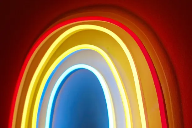 Glowing neon rainbow light on a red wall