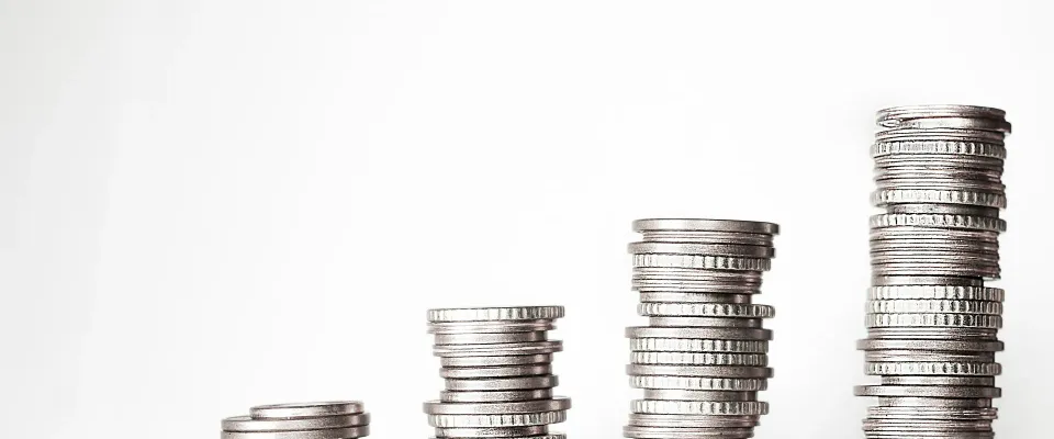 Five stacks of silver coins rising from short to tall