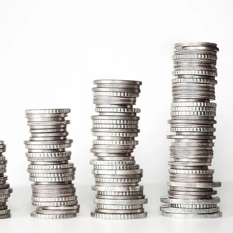 Five stacks of silver coins rising from short to tall